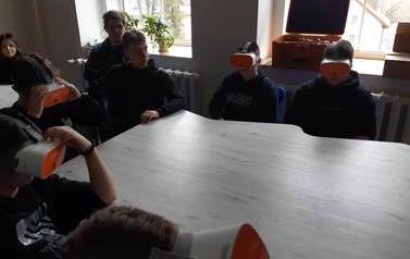 Pięciu chłopc&oacute;w ma założone gogle vr, dwaj pozostali i uczennica przyglądają im się.