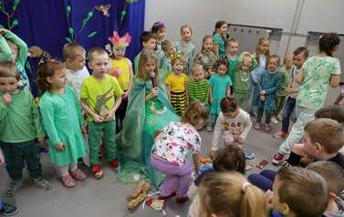 Dwie dziewczynki zbierają rozrzucone na scenie śmieci. Dziewczynka w przebraniu wiosny, m&oacute;wi do mikrofonu.