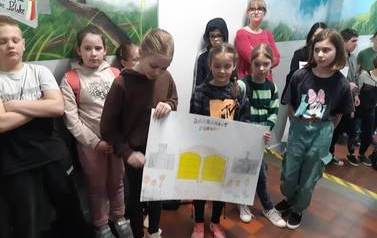Uczennice klasy czwartej prezentują plakat na temat pokuty.