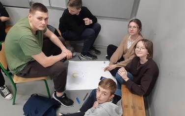 Uczniowie i uczennice klasy &oacute;smej wykonują plakat na temat bierzmowania.