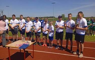 Piłkarze stoją na boisku w oczekiwaniu na dekorację medalową.