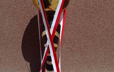 Na zdjęciu puchar za zdobycie II miejsca w Gminnym Turnieju Piłki Nożnej o Puchar W&oacute;jta Gminy Ełk. Na trofeum przewieszone dwa medale.