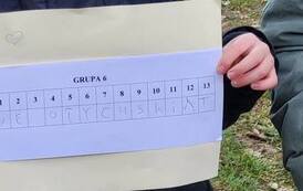 Na zdjęciu dziecko prezentuje kartkę z rozwiązaniem zagadek.