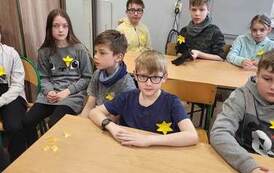 Chłopcy z klasy IV biorą udział w zajęciach poświęconych rocznicy wybuchu powstania w getcie. Mają przypięte ż&oacute;łte żonkile.